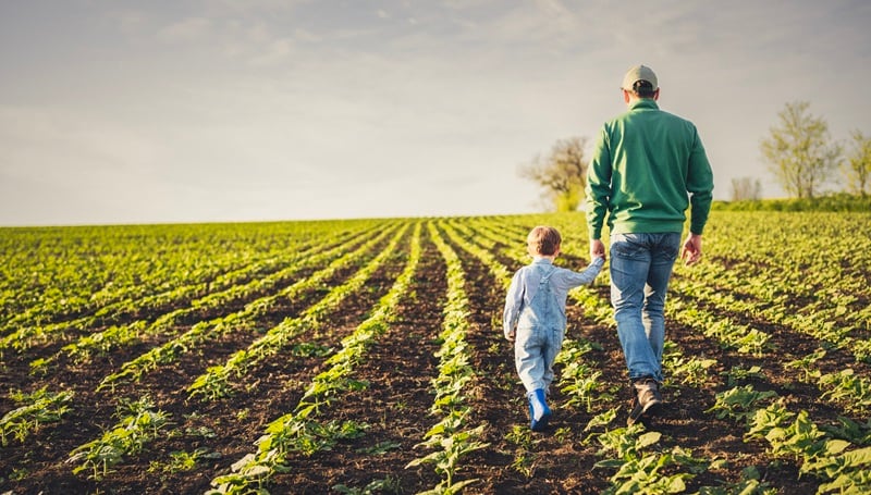 A farmer and his child in a field
