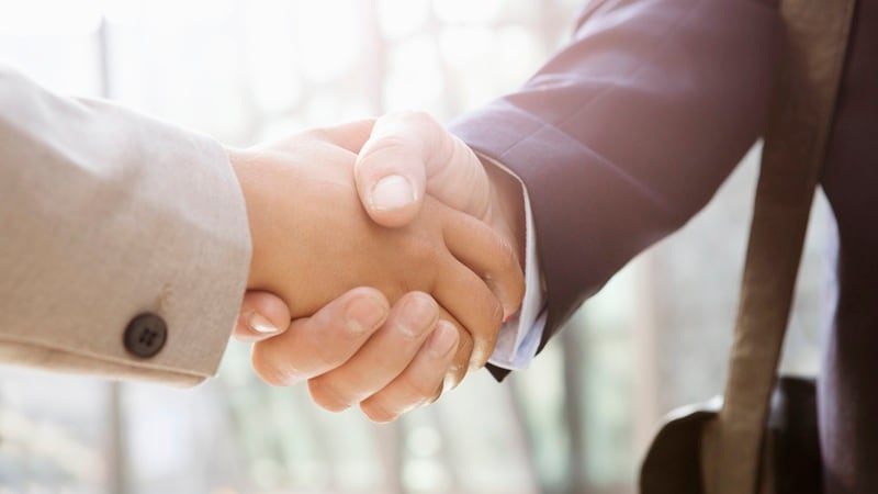 Two people shaking hands in a business setting