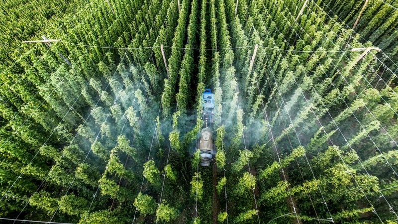 A tractor spraying herbicide in a field