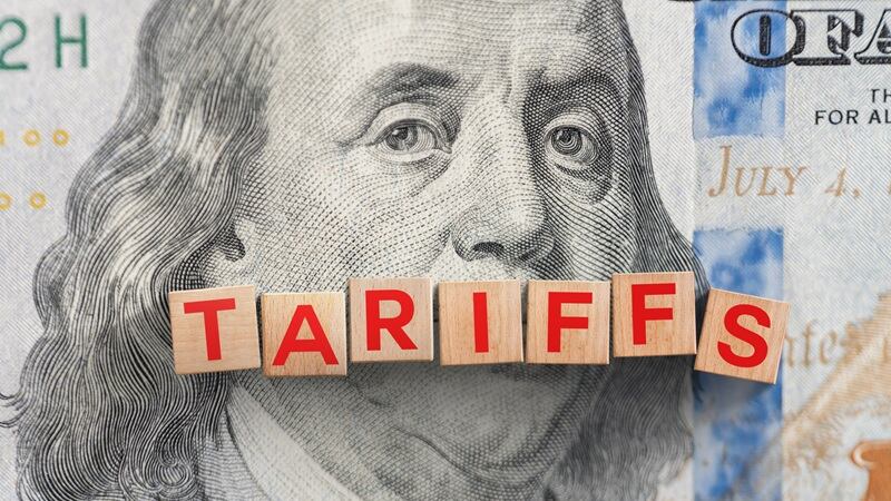 A $100 bill with the words tariffs