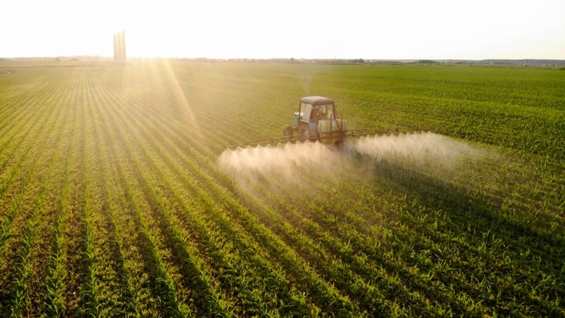 A tractor spraying a chemical in a field